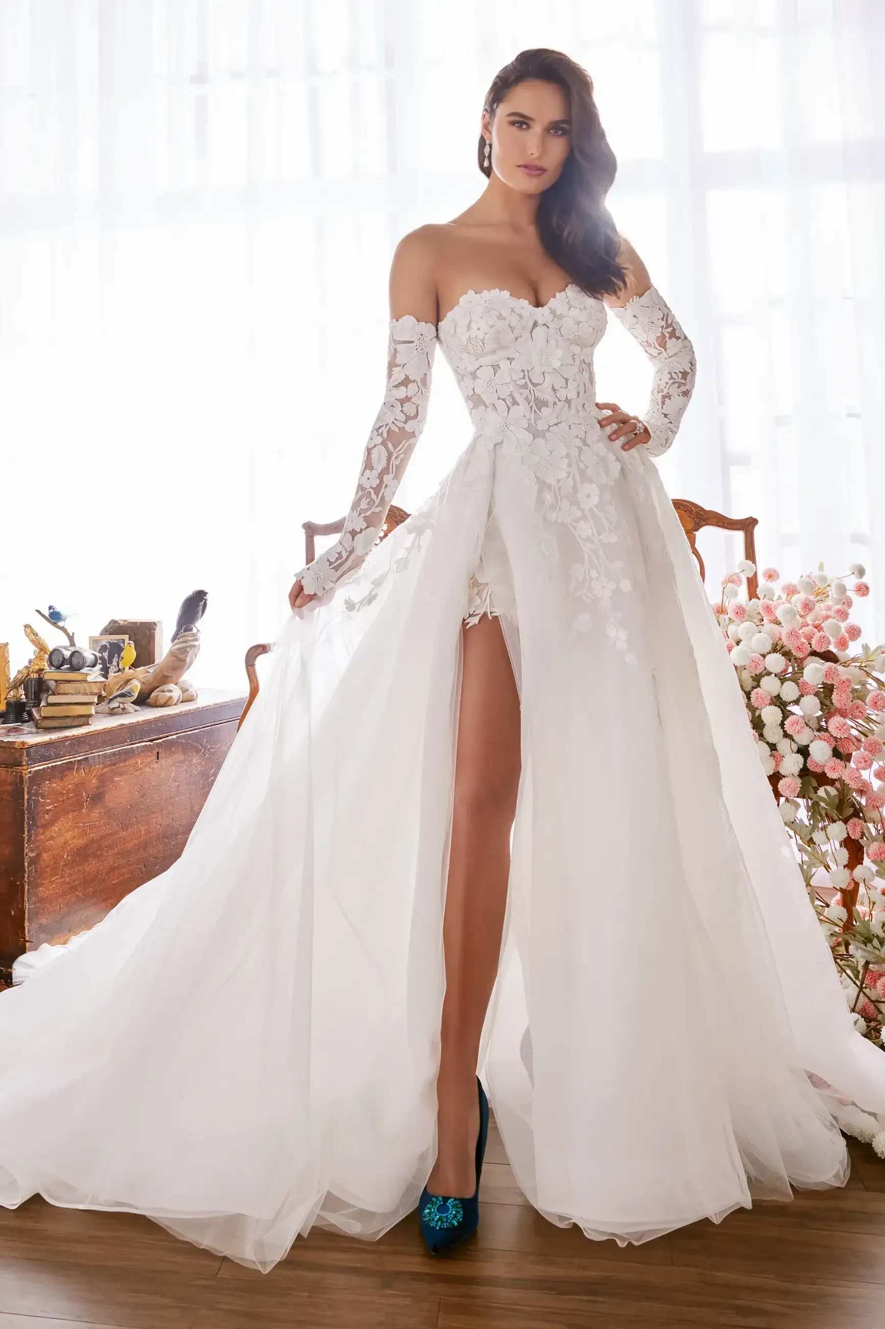 model is wearing a strapless bridal gown with detachable off the shoulder wedding dress with a slit