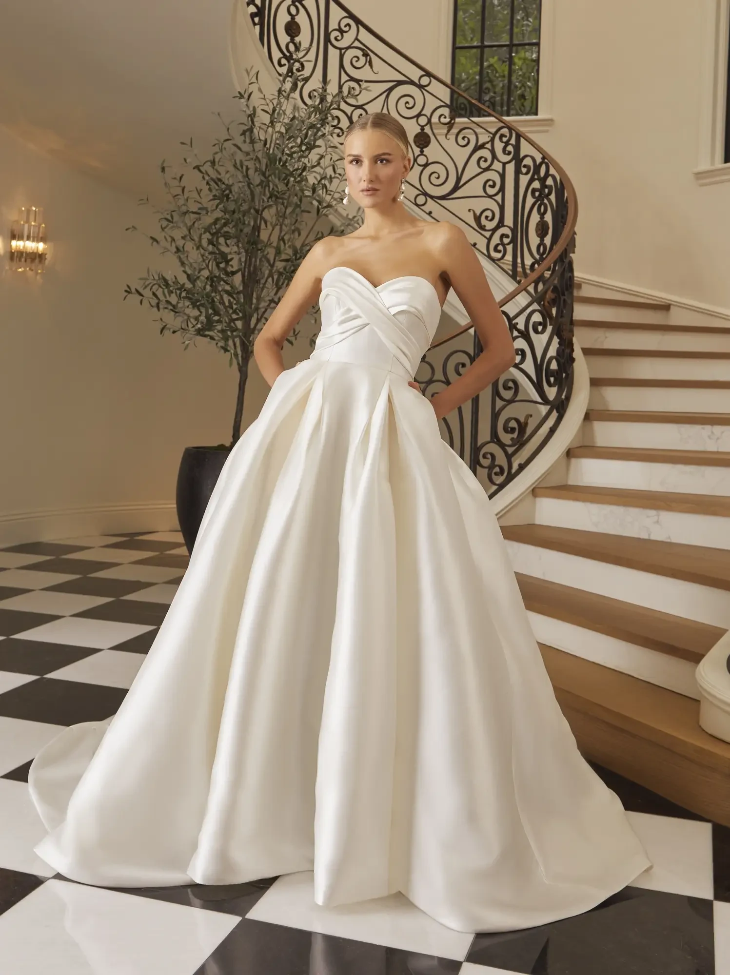 model is wearing a strapless ball gown wedding dress