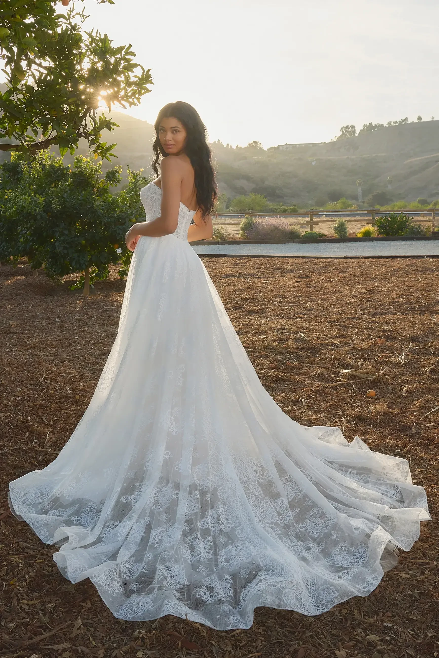 model is wearing a strapless bridal gown with a train