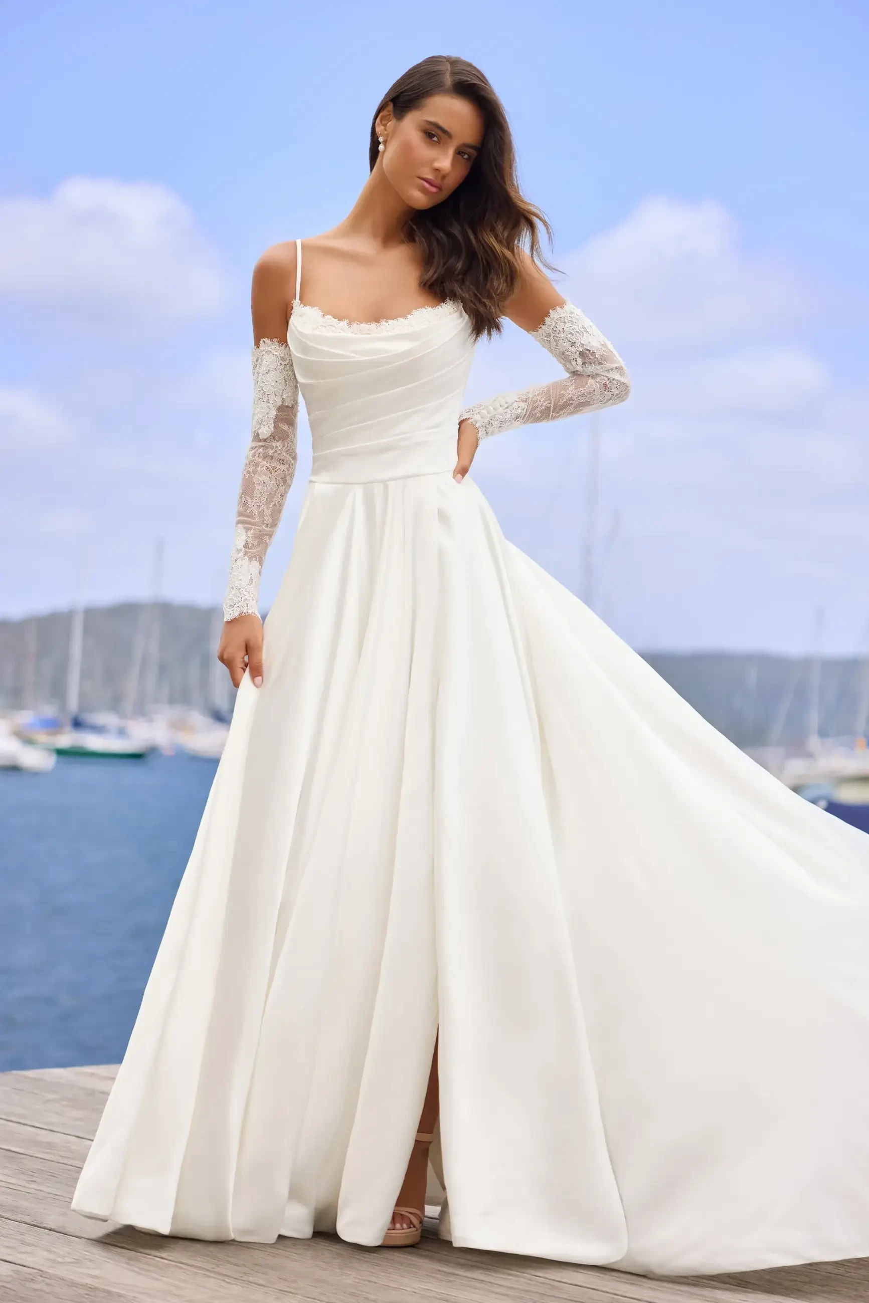 model is wearing an off the shoulder a-line wedding dress by sophia tolli
